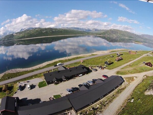 A lakeside property with multiple buildings, a parking area, and a road leading to the water.