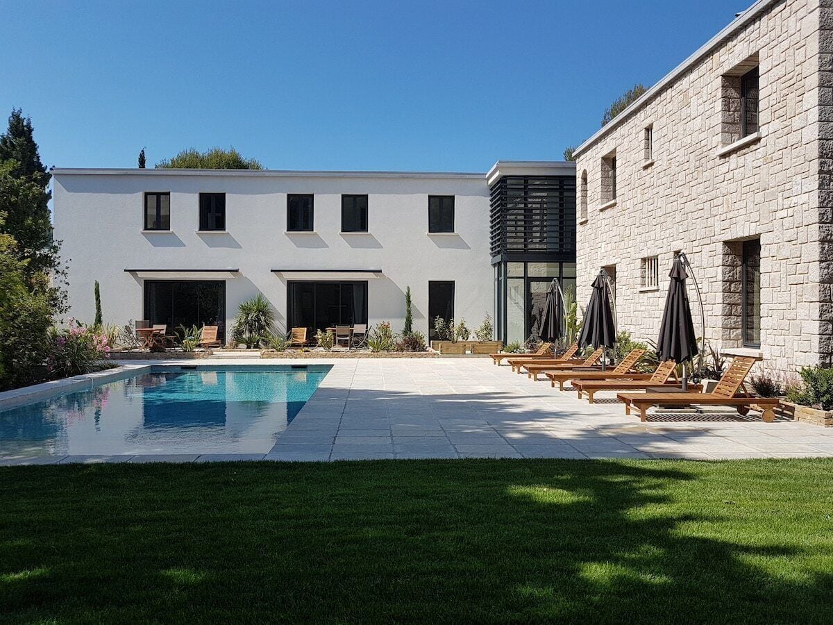A modern building with a swimming pool and lounge area.
