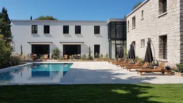 A modern building with a swimming pool and lounge area.
