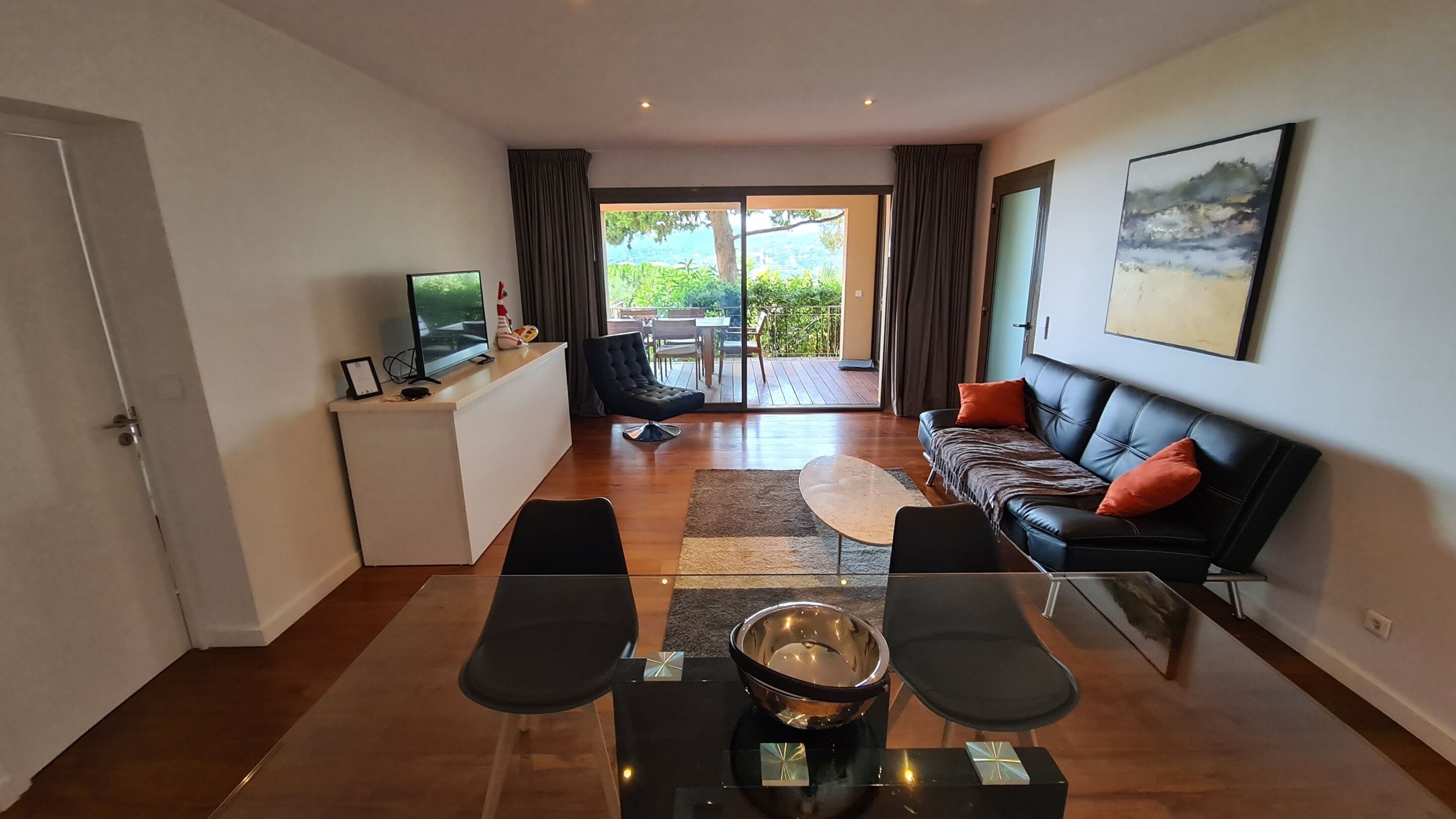 A modern living room with a sofa, coffee table, and a dining area with chairs.