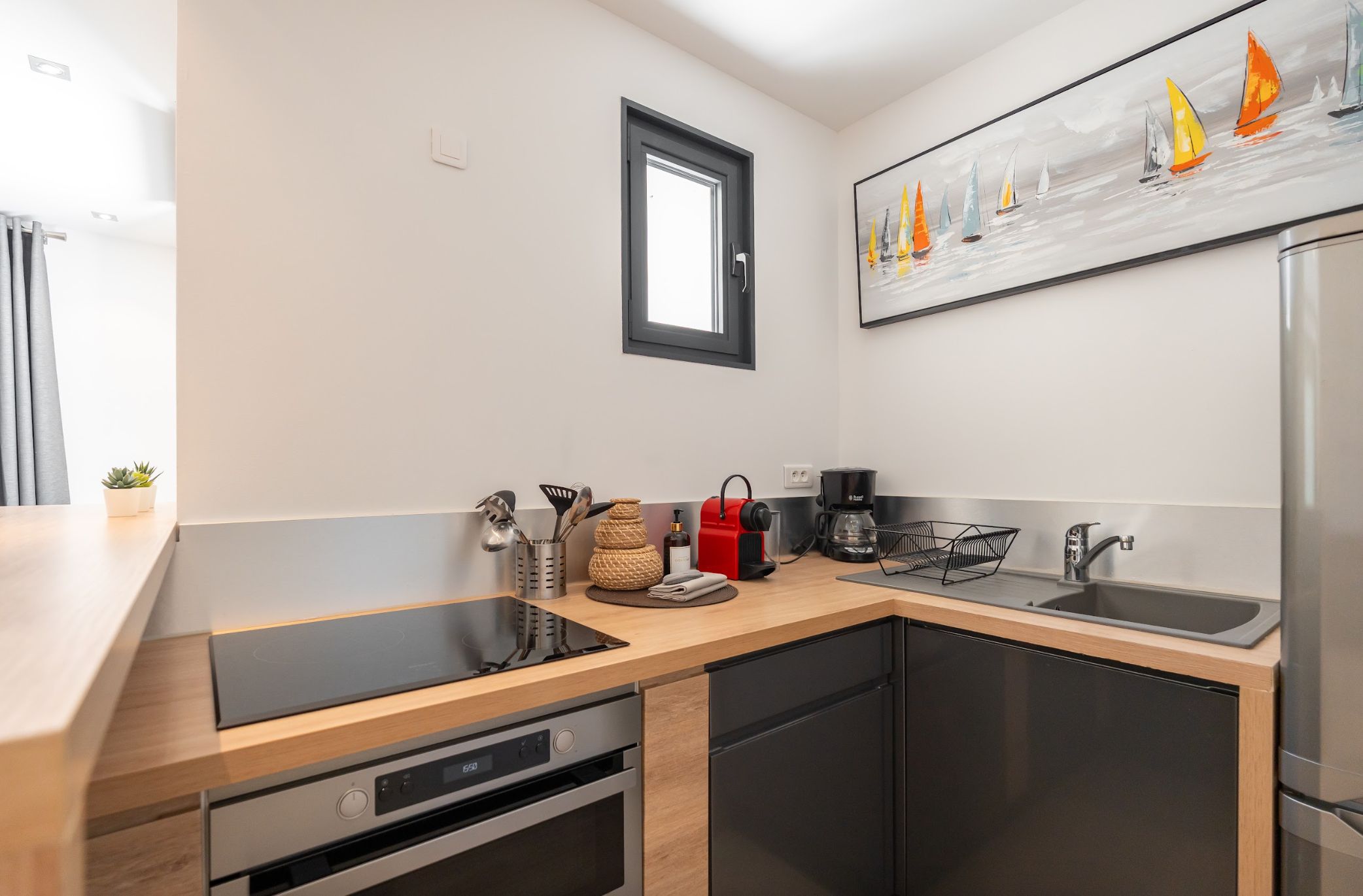 A modern kitchen with a built-in dishwasher, a coffee maker, and a sink.