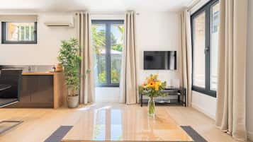 Un salon moderne avec une table basse en bois, une plante en pot et un téléviseur fixé au mur.