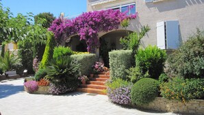 A two-story house with a covered entrance, surrounded by well-maintained gardens and a paved driveway. - Hôtel Particulier Cassis, Parking sécurisé, Piscine chauffée (Cassis)
