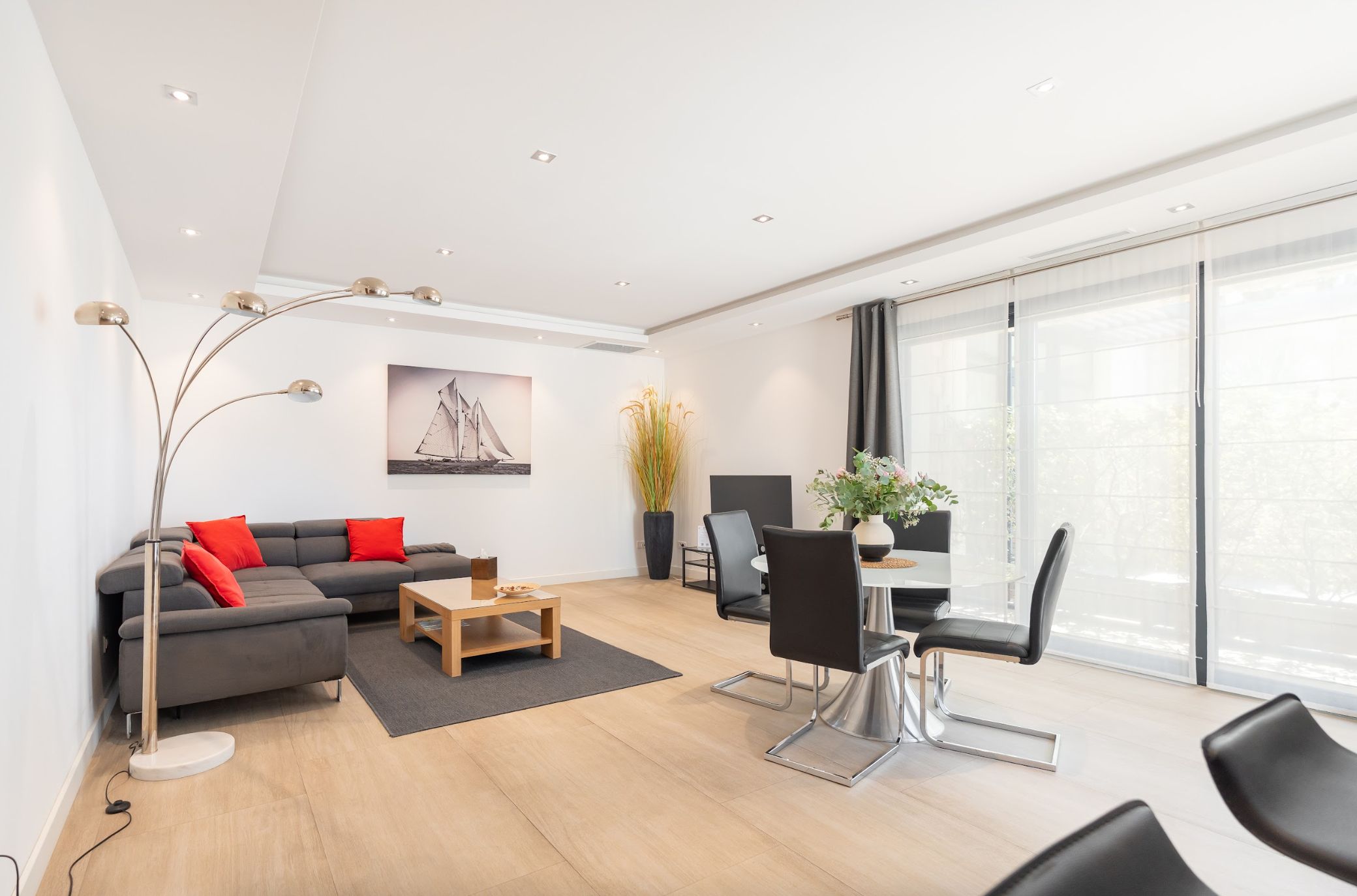 Un salon moderne avec un canapé, une table basse et un coin repas.