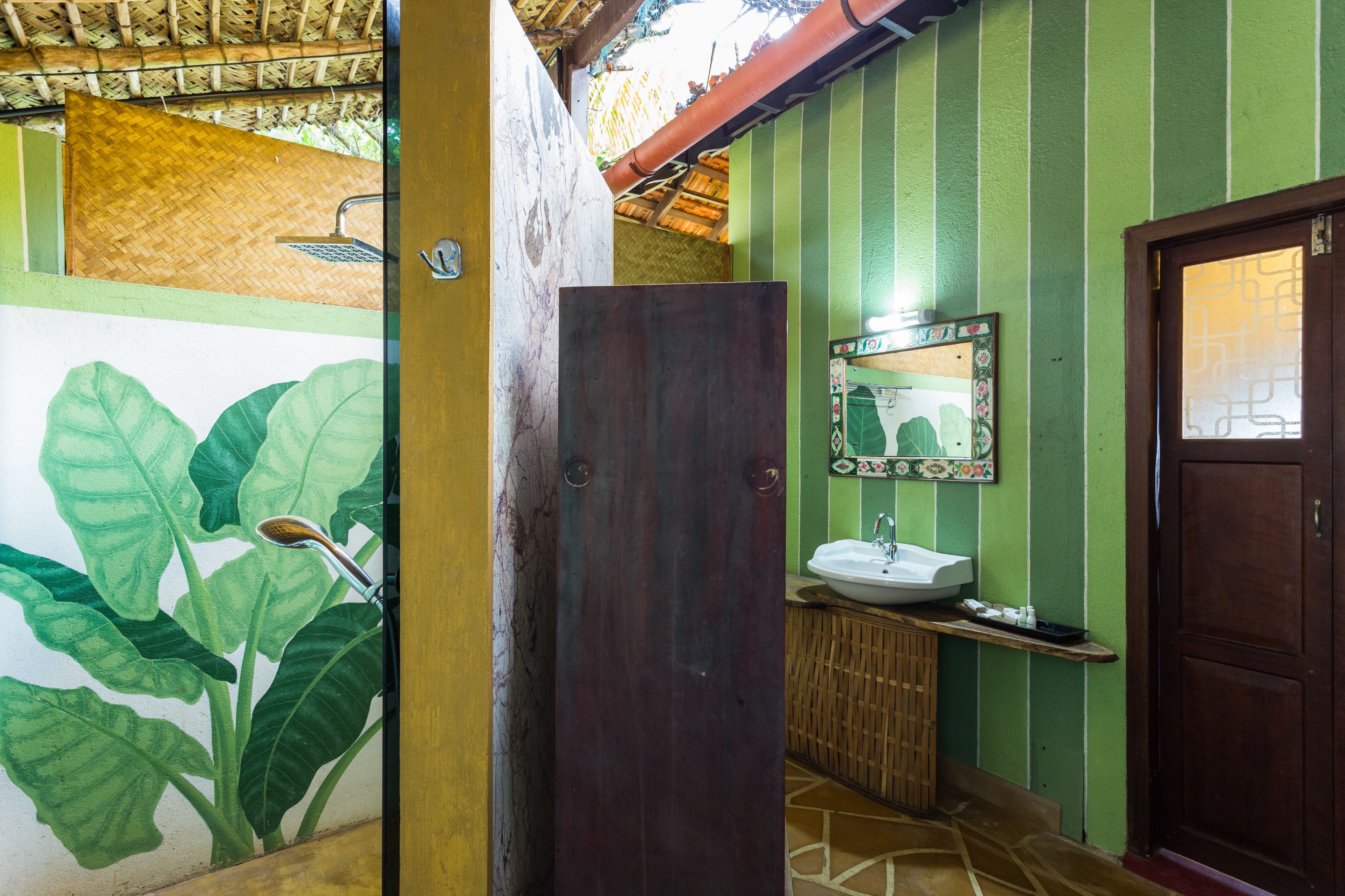 Une salle de bain avec un grand miroir, un lavabo et une douche.