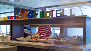 A buffet area with various food items and a sign above displaying "HOTEL".