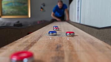 Una mesa de shuffleboard con discos rojos, azules y plateados.