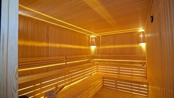 Eine Sauna mit Holzbänken und schrägverdeckter Decke.