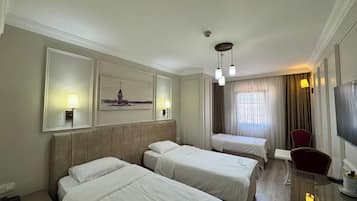 A hotel room with two beds, a desk, a chair, a TV, and a painting on the wall.