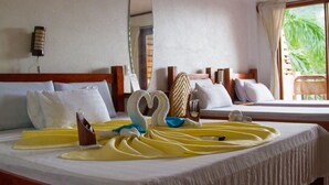 Una habitación de hotel con una cama bien hecha, un espejo, una ventana con vistas a zonas verdes y un cabecero de madera.