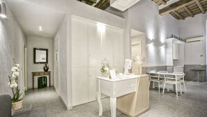 A modern bathroom with a vanity, mirror, and seating area. - History Suite (Rome)