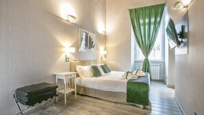 A bedroom with a bed, bedside tables, a suitcase, and a window with green curtains. - History Suite (Rome)
