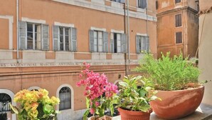 A building facade with multiple windows and a plaque with text. - History Suite (Rome)