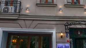 A building with multiple windows and balconies, a sign for 'Stay Inn', and a visible entrance with a glass door. - Stay Inn Taksim Hostel (Istanbul)