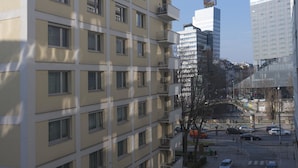 A multi-story building with a beige facade, multiple balconies, and a parking area in front. - Heart of Vienna Residence (Vienna)