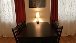 A dining table with four chairs, a table lamp, and a framed artwork on the wall. - Heart of Vienna Home (Vienna)