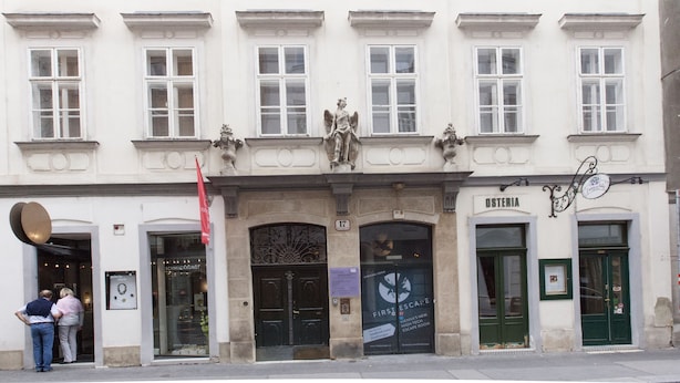 A historic building with a central entrance, flanked by two doors labeled "Osteria" and "First Escape." - Heart of Vienna Home (Vienna)