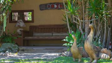 Un jardin avec un canapé, une lampe et une sculpture en bois.
