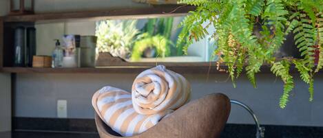 A wooden bowl with a rolled towel on a kitchen counter.