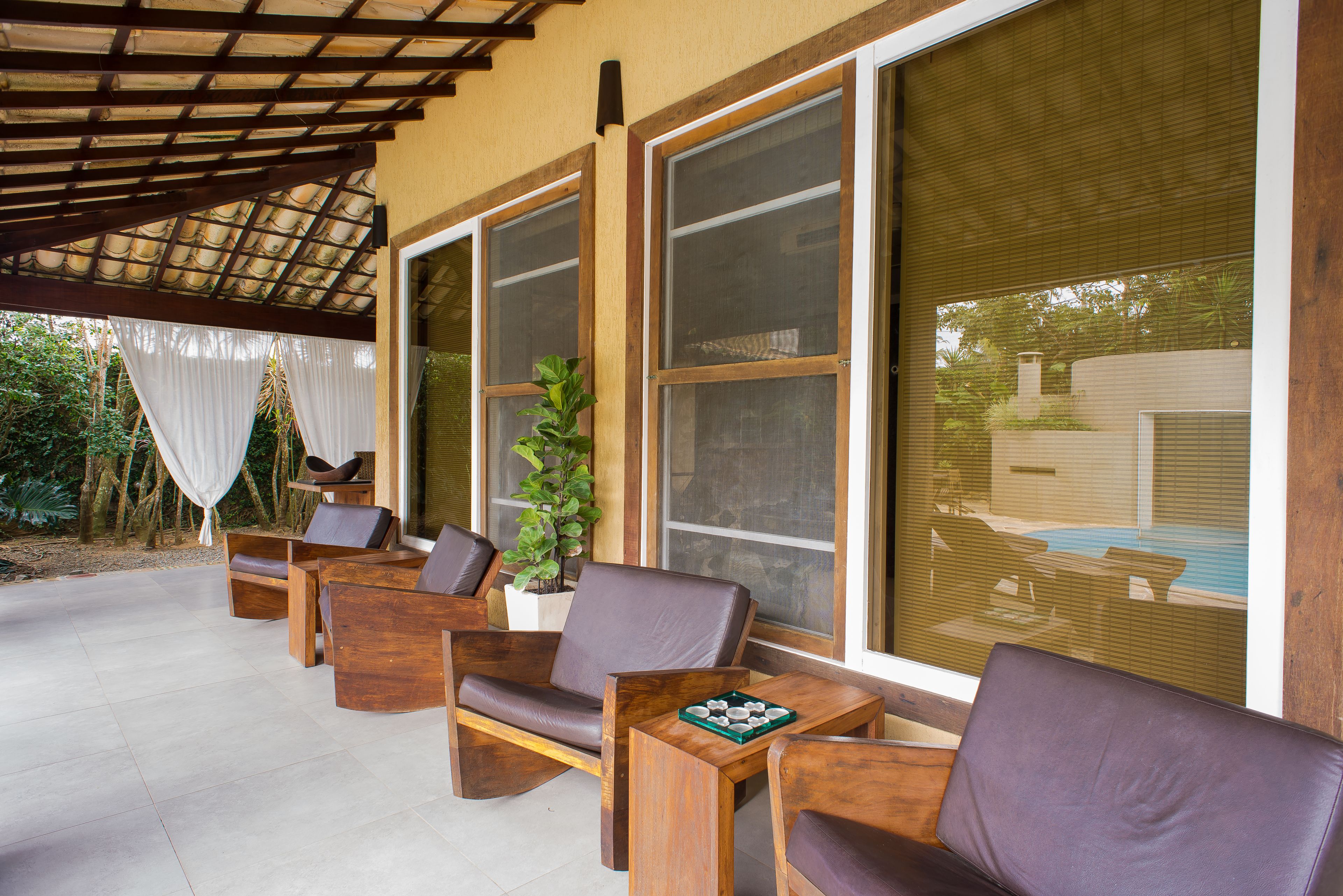 Un espacio al aire libre con mobiliario de madera y ventanas amplias.