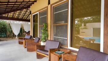 Un espacio al aire libre con mobiliario de madera y ventanas amplias.