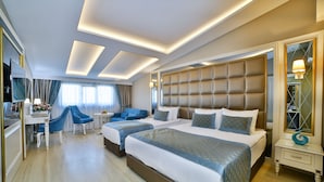 Habitación de hotel con una cama grande, un escritorio, una silla y un espejo.