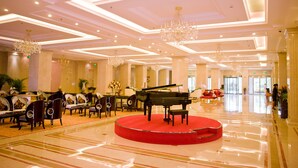 A grand lobby with a grand piano on a red carpet, elegant chandeliers, and a seating area with sofas and chairs. - Jinling Cityview Hotel Zhenjiang (Zhenjiang)