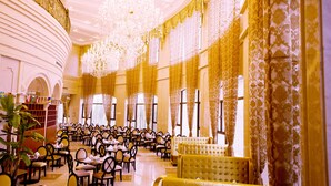 A banquet hall with round tables and chairs, a large chandelier, and ornate curtains. - Jinling Cityview Hotel Zhenjiang (Zhenjiang)