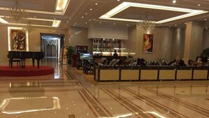 A spacious lobby with a grand piano, a bar area, and a seating area with a red carpet. - Jinling Cityview Hotel Zhenjiang (Zhenjiang)