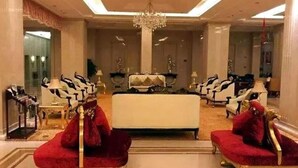 A luxurious hotel lobby with a grand chandelier, plush red sofas, and classic white and gold furniture. - Jinling Cityview Hotel Zhenjiang (Zhenjiang)