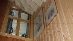 A wooden interior with a window, wooden walls, and a framed picture. - Center Villa (Bergen)