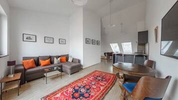 Deluxe-Suite, Balkon, Stadtblick | Wohnbereich | Flachbildfernseher