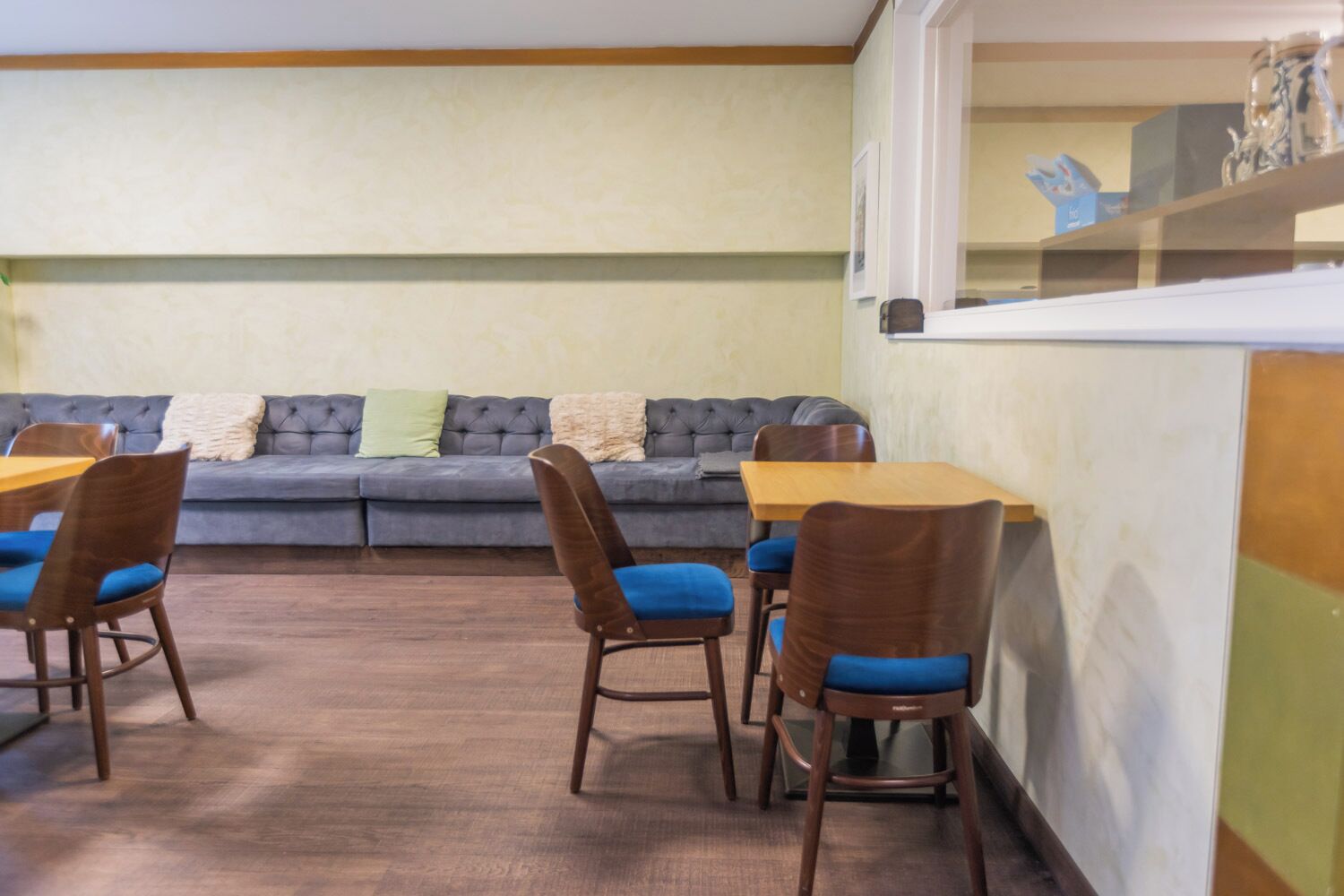 Ein Essbereich mit einer Couch, Stühlen, einem Holztisch und einer Küchenzeile.