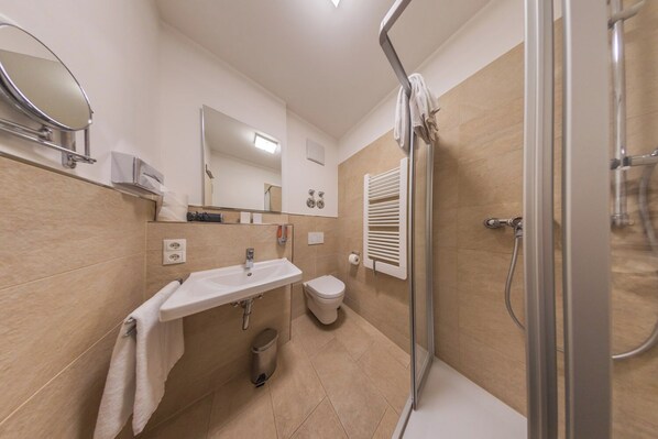 A modern bathroom with a sink, toilet, and shower.