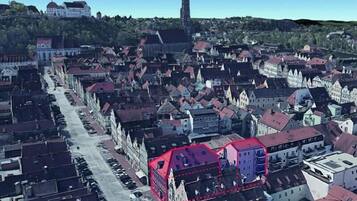 Et bybillede med et markant kirketårn, tætte historiske bygninger og en klar himmel.