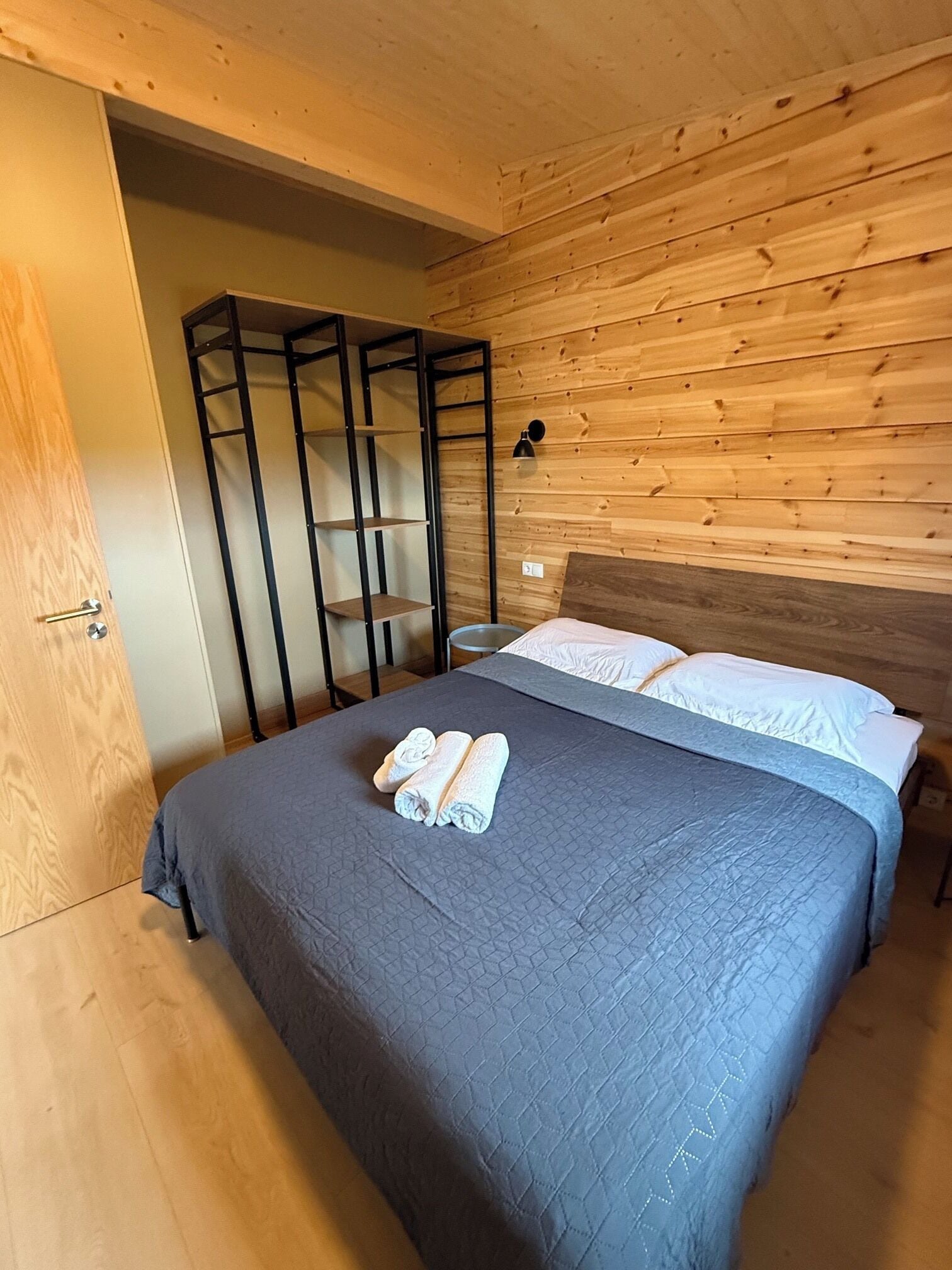 A bedroom with a bed, a wardrobe, and a nightstand.