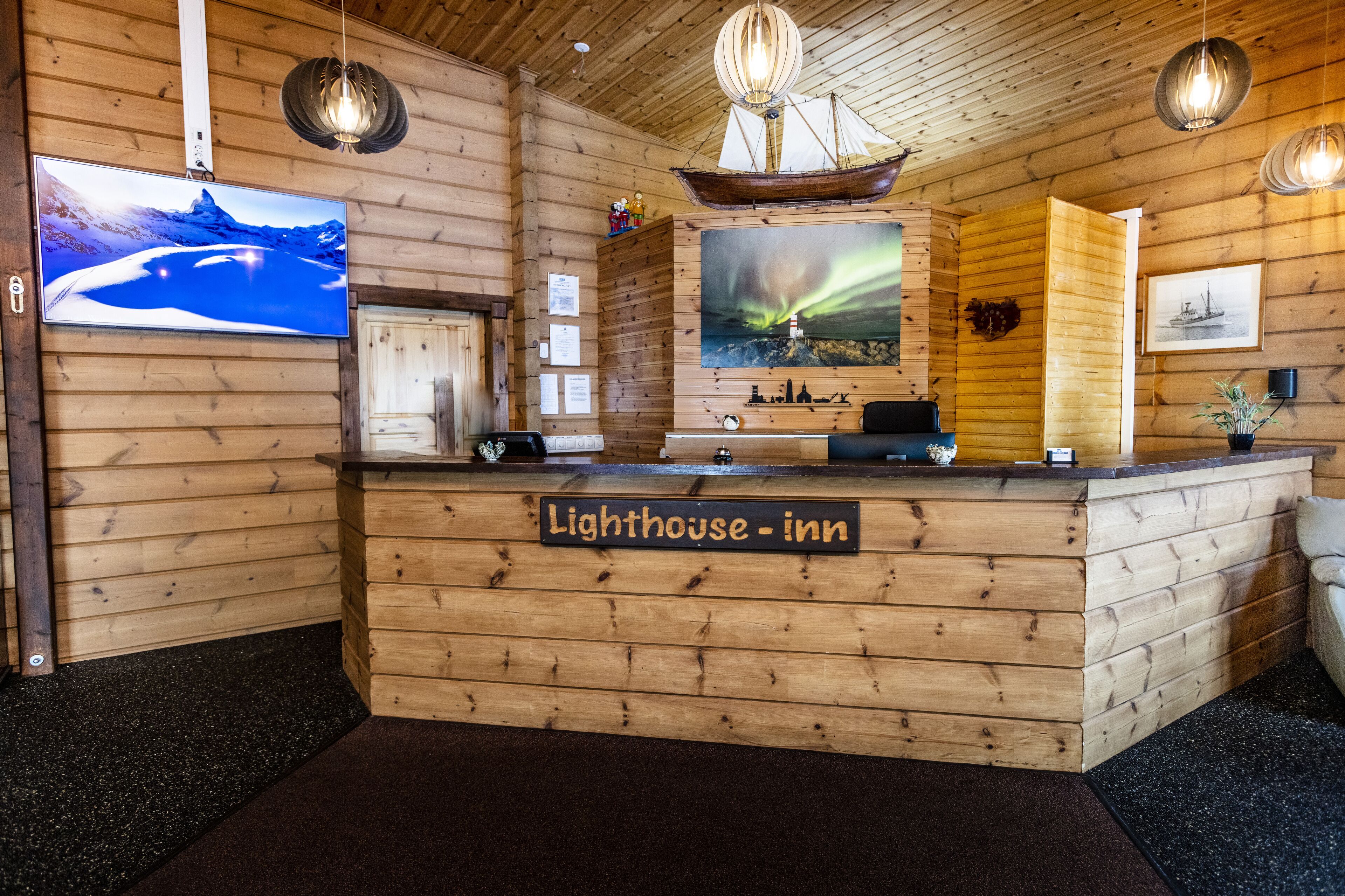 A wooden reception desk with a sign reading "Lighthouse Inn."