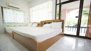 A bedroom with two beds, a large window, and a sliding glass door to a balcony. - Chaiwat Resort (Laem Sing)