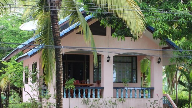 A two-story house with a balcony, surrounded by lush greenery. - Chaiwat Resort (Laem Sing)