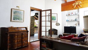 A cozy living room with a wooden cabinet, a fireplace, and a television. - La Rouine - Morgex (Morgex)