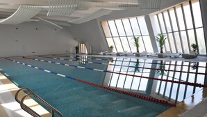A swimming pool with clear lanes, a sunlit interior, and a view of the outdoors through large windows. - CITIC Jinling Hotel (Pinggu)