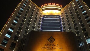 Un edificio de gran altura con señalización iluminada y el nombre del hotel en la parte superior.