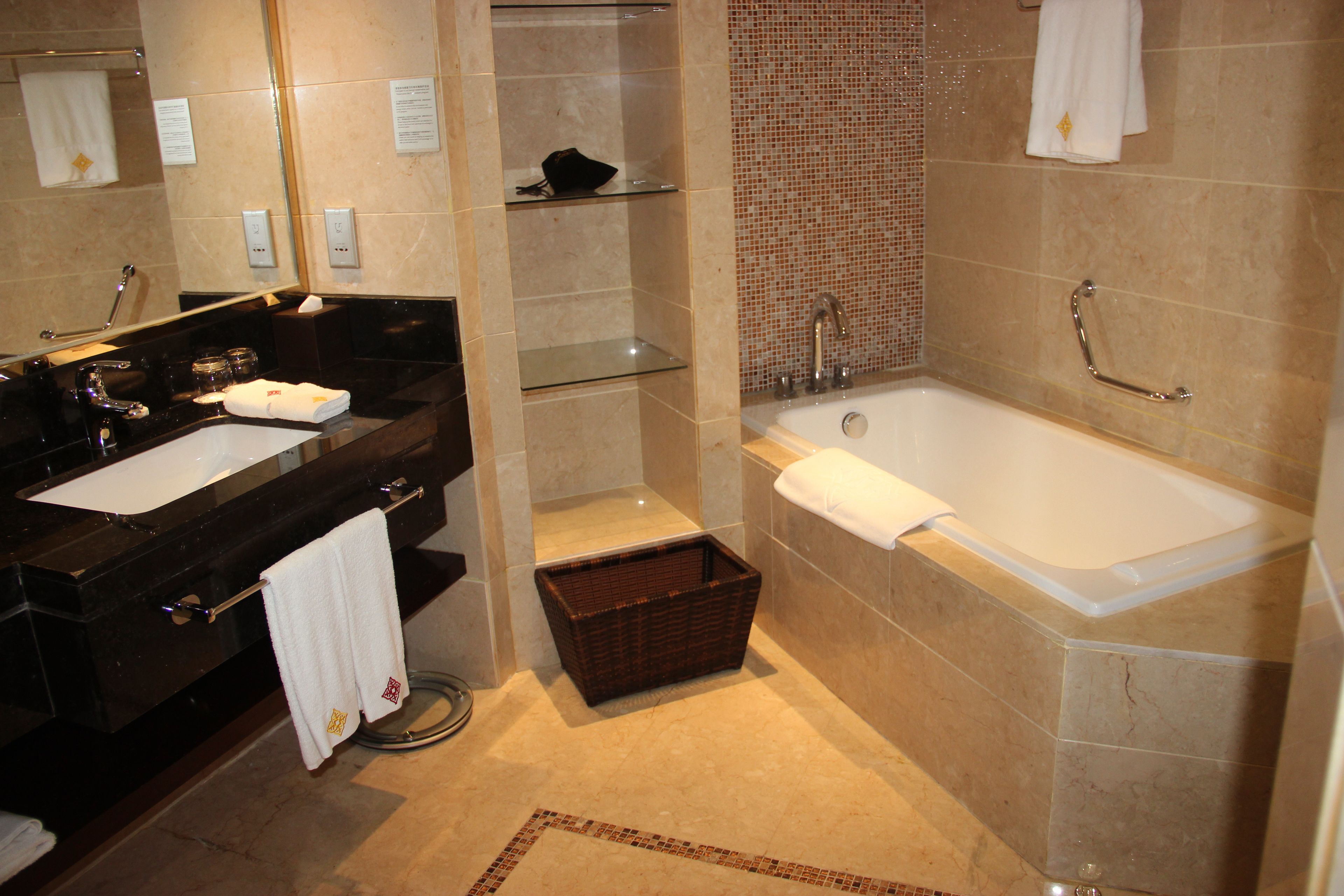 A modern bathroom with a black vanity, a large bathtub, and a shower area.