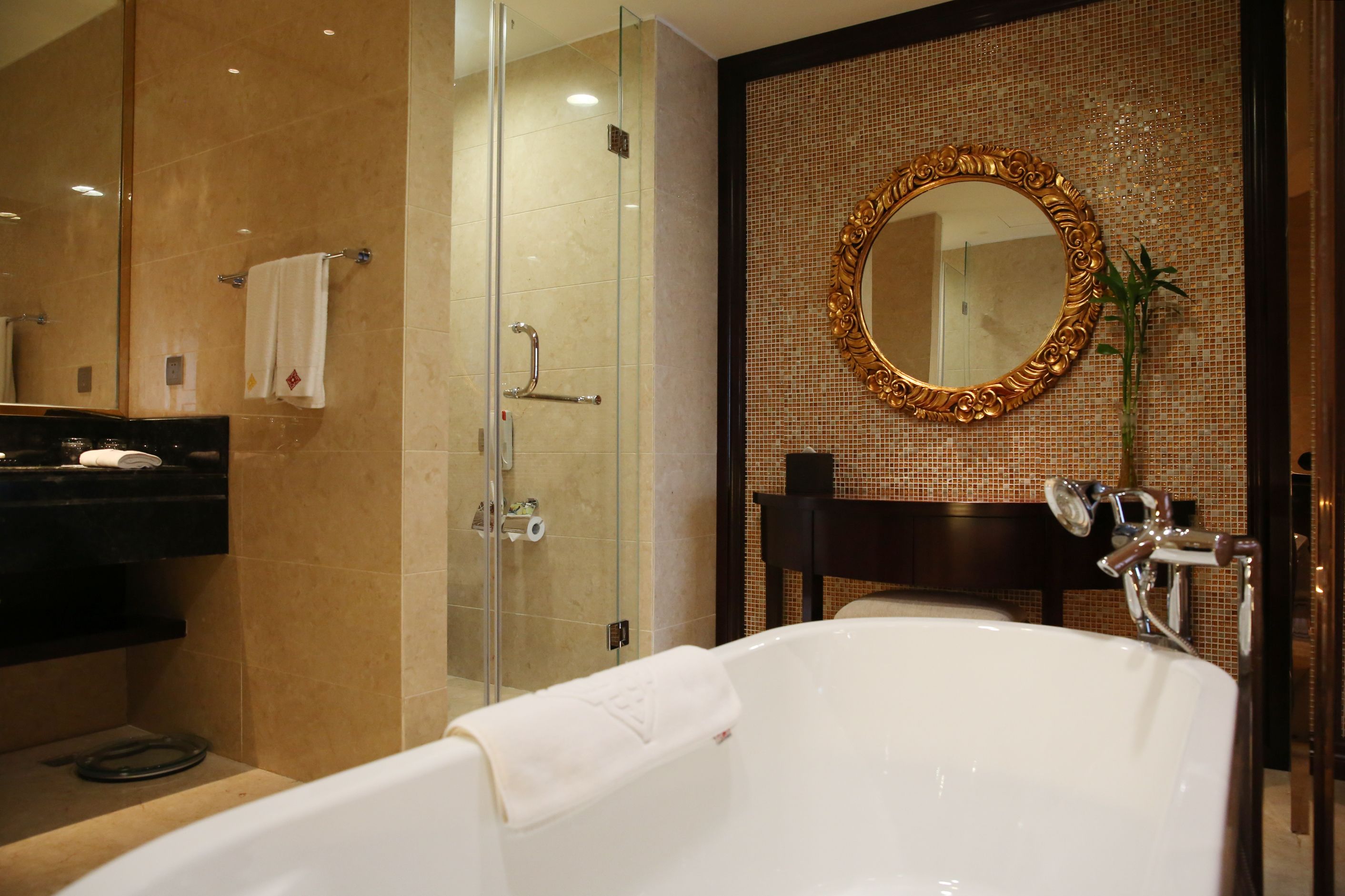A modern bathroom with a glass-enclosed shower, a large mirror, and a bathtub.