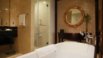 A modern bathroom with a glass-enclosed shower, a large mirror, and a bathtub.