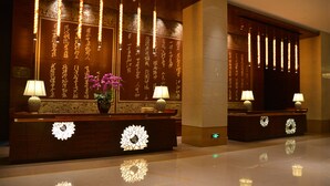 A reception desk with decorative lighting and floral arrangements. - Jinling Yew Resort Wuxi (Wuxi)