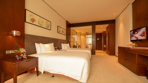 A hotel room with two beds, a TV, a desk, and a bathroom visible through an open door. - Jinling Yew Resort Wuxi (Wuxi)