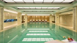 Uma piscina interior ampla com área de estar e balcão de recepção.