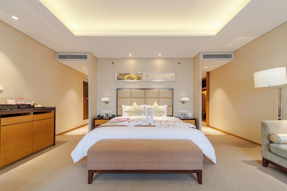 Ein modernes Hotelzimmer mit einem großen Bett, einem Schreibtisch und einem Stuhl.