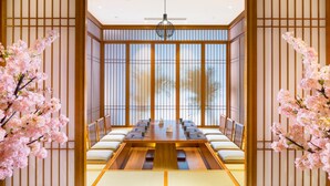 Um quarto tradicional japonês com tatames, uma mesa baixa e biombos de papel.